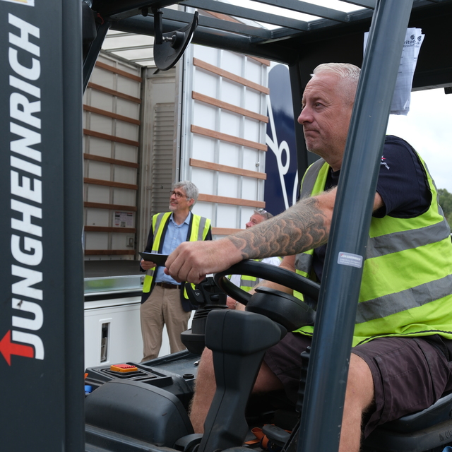 Driver from Bradshaw Moving Services carefully loading furniture into a van in Birmingham.